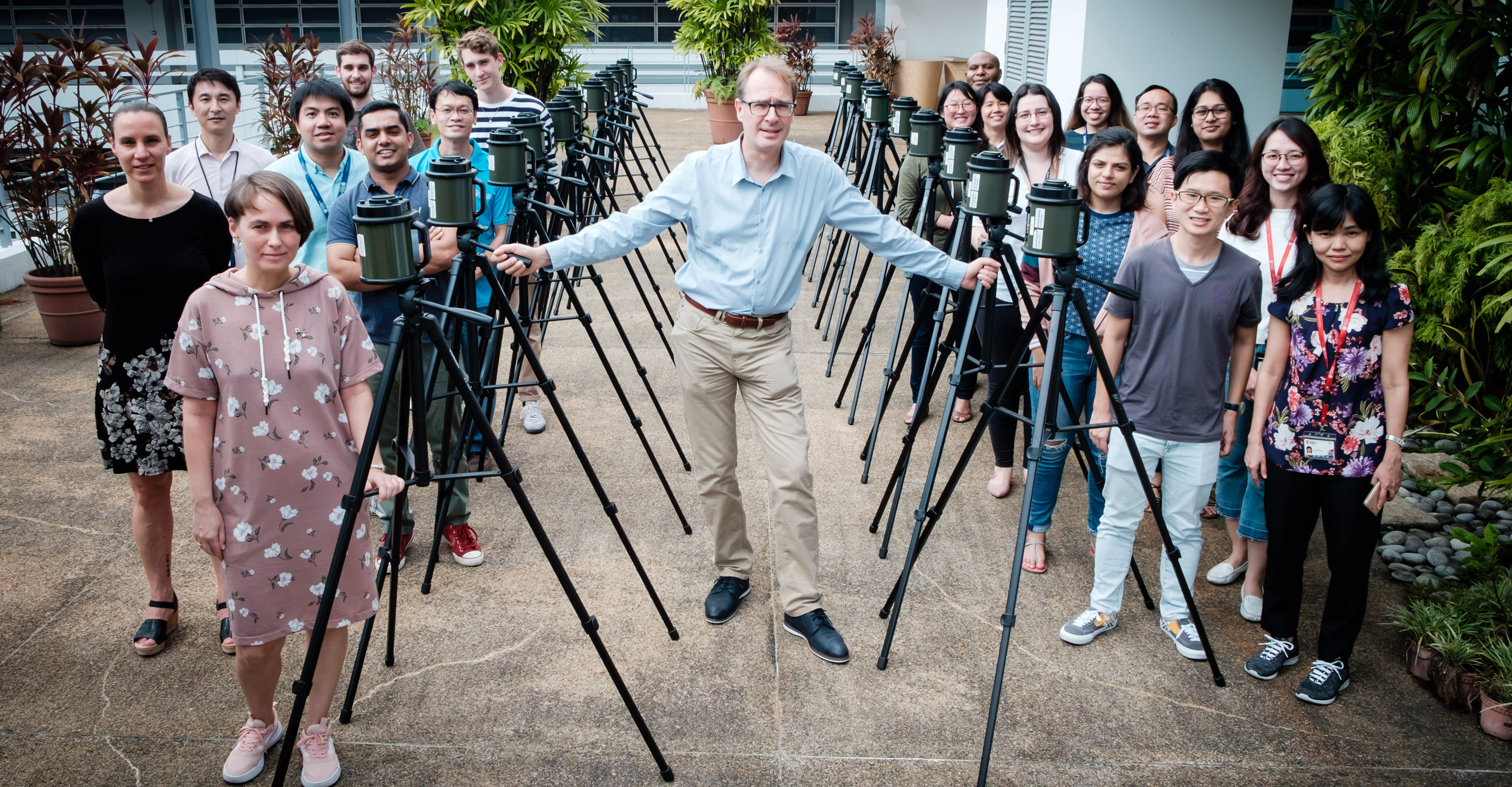 SCELSE air microbiome team members gather outside on NTU balcony with high volume air samplers